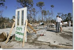 President George W. Bush stands with Al Boyd in the ruins of where Boyd's home used to be during a walking tour of neighborhoods damaged by Hurricane Ivan in Pensacola, Florida, Sunday, Sept. 19, 2004. White House photo by Eric Draper.