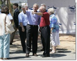 President George W. Bush is joined by Biloxi, Miss. Mayor A.J. Holloway, right, Monday, Aug. 28, 2006, during President Bushs walking tour in the same Biloxi neighborhood he visited following Hurricane Katrina in September 2005. The tour allowed President Bush the opportunity to assess the progress of the areas recovery and rebuilding efforts following the devastating hurricane. White House photo by Eric Draper